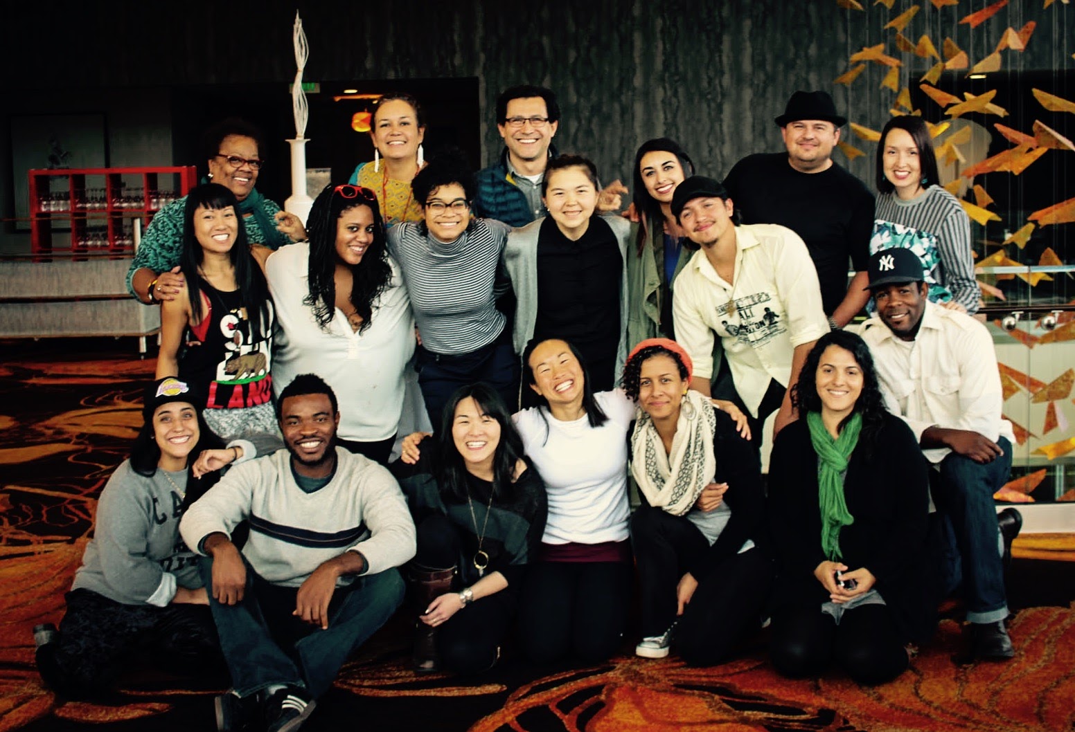 Group photo of a previous cohort. Three rows of 18 people grouped together smiling